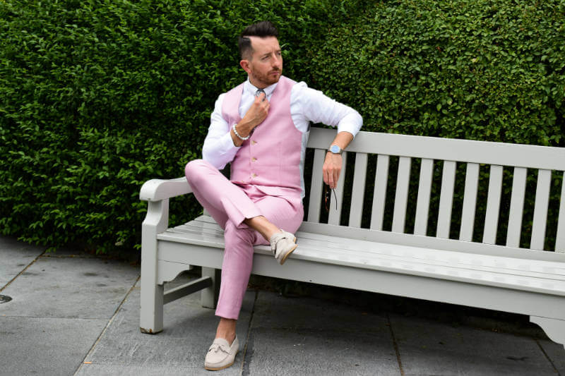 Fixing my tie in a pink waistcoat on a bench