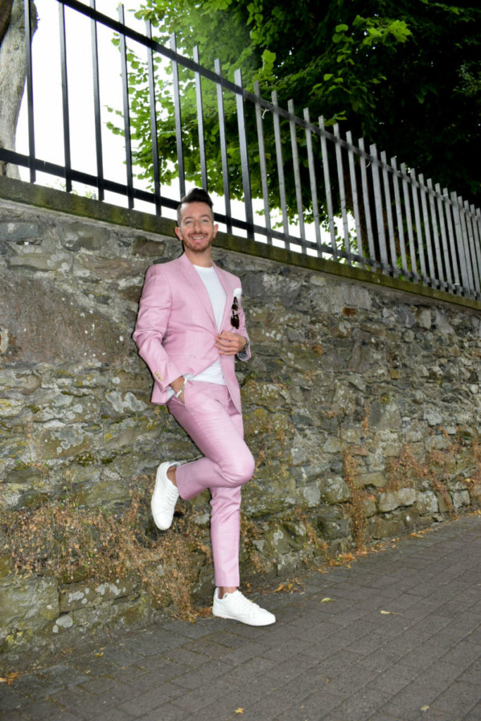 Pink Suit posing against a wall